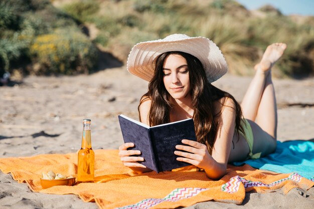 Bezpłatne zdjęcie kobiety czytelnicza książka przy plażą