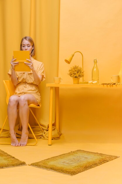 Bezpłatne zdjęcie kobiety czytelnicza książka w żółtej scenie