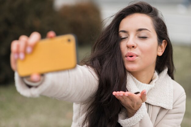 Kobiety dmuchania buziak podczas gdy brać selfie