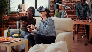 Kobiety grające w gry wideo z okularami vr na konsoli, używające zestawu słuchawkowego 3d wirtualnej rzeczywistości do gry w rywalizację. zabawa z symulacją gry na imprezie, picie piwa.
