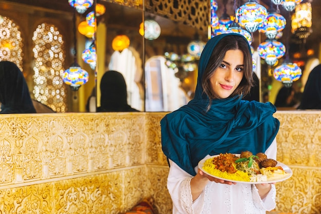 Bezpłatne zdjęcie kobiety mienia naczynie arabski jedzenie