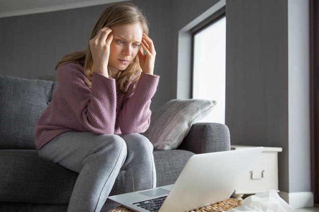 Kobiety Mienia Palce Na świątyniach, Patrzeje Laptop Na Stole