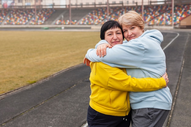 Bezpłatne zdjęcie kobiety na stadionie przytulanie