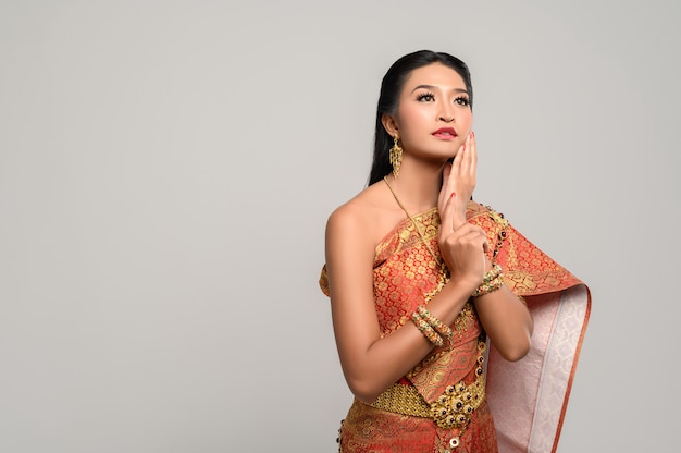 Kobiety noszące tajskie ubrania i dłonie dotykające twarzy