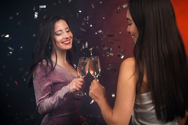 Kobiety opiekania z szampanem na imprezie noworocznej