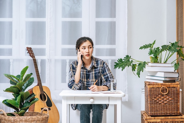 Kobiety Siedzą Przy Biurku I Koordynują Za Pomocą Telefonu.