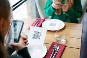 Bezpłatne zdjęcie kobiety skanują kod qr w restauracji