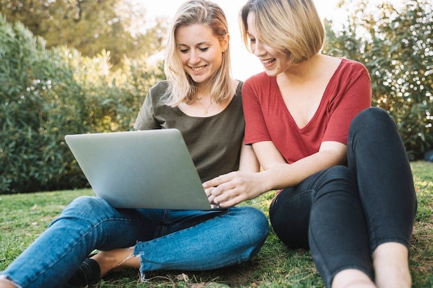 Kobiety używają laptopa na ziemi