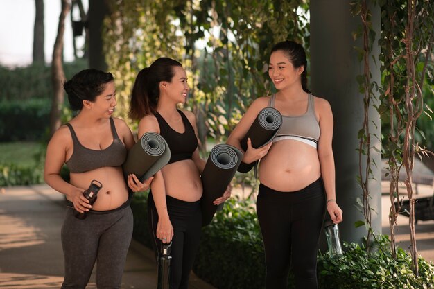 Kobiety w ciąży trzymające maty do jogi