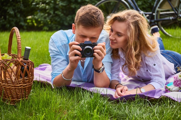 Kochająca młoda para fotografuje i relaksuje się na pikniku w parku.