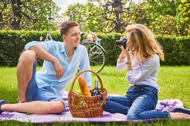 Kochająca para na pikniku w parku. Blond kobieta strzelanie do swojego chłopaka.