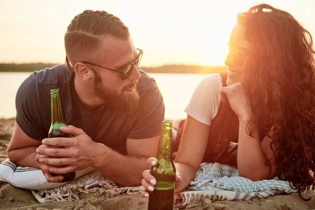 Kochająca para pijąca piwo na plaży?