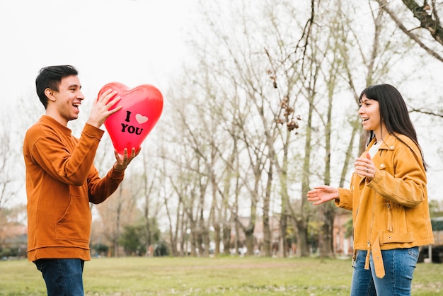 Bezpłatne zdjęcie kochający szczęśliwy pary łapania balon outdoors