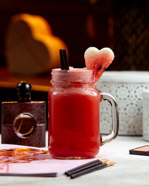 Bezpłatne zdjęcie koktajl z arbuza w słoiku z masonem przyozdobionym arbuzem w kształcie serca