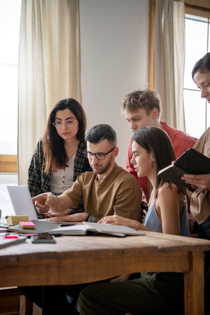 Koledzy czytają za pomocą laptopa podczas sesji szkoleniowej