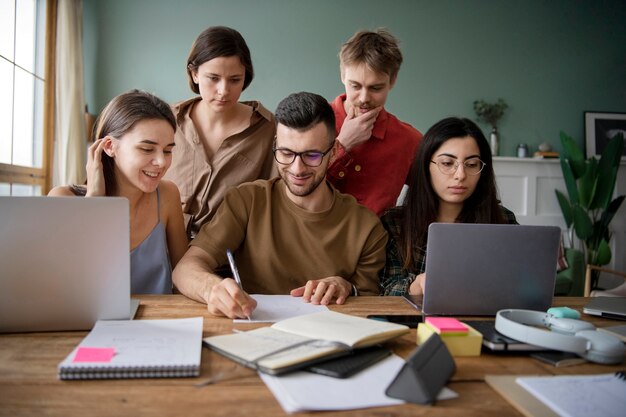 Koledzy korzystający z laptopów i notebooków do nauki podczas sesji szkoleniowej