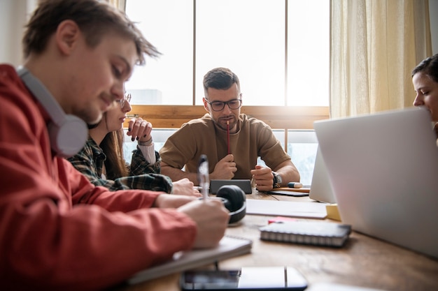 Bezpłatne zdjęcie koledzy studiujący w bibliotece przy użyciu laptopów i notebooków