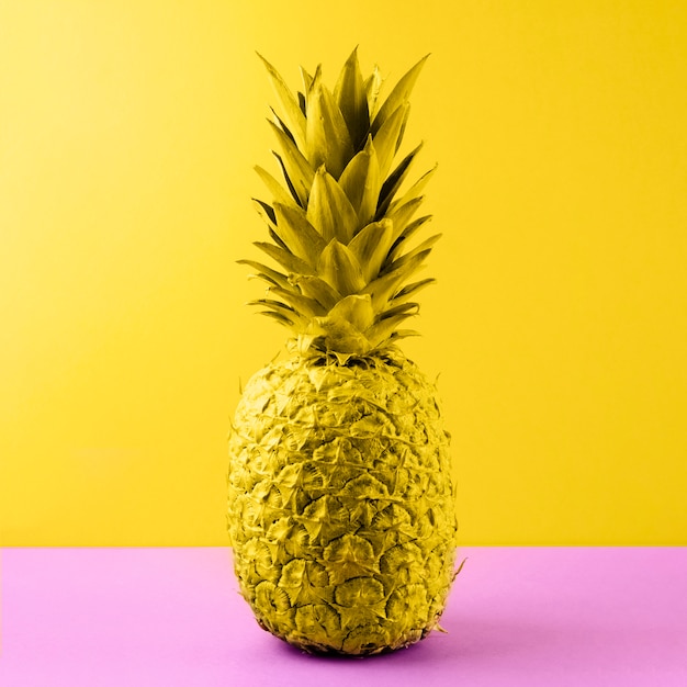 Kolor żółty Malujący Ananas Na Różowym Biurku Przeciw Barwionemu Tłu