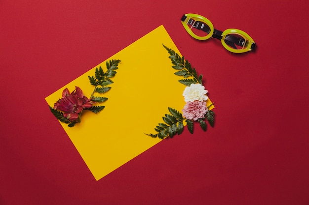 Kolorowa kompozycja z tropikalnych kwiatów i okularów