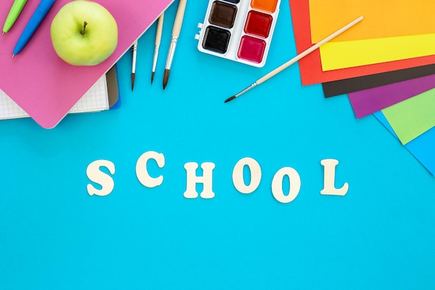 Bezpłatne zdjęcie kolorowe artykuły szkolne na niebieskim tle koncepcja powrotu do szkoły
