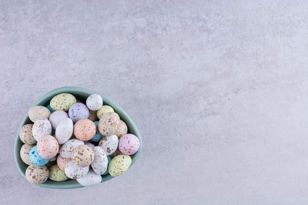 Kolorowe kamienne cukierki w tacach na betonowym tle. Zdjęcie wysokiej jakości