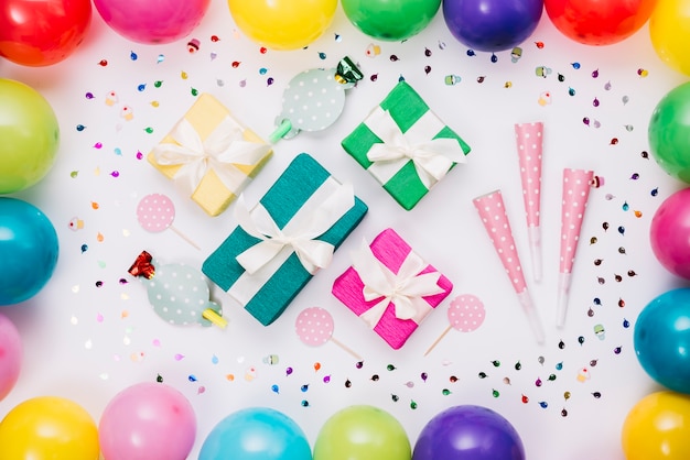 Kolorowe pudełka na prezenty; róg imprezowy; prop ozdobiony konfetti i balonów