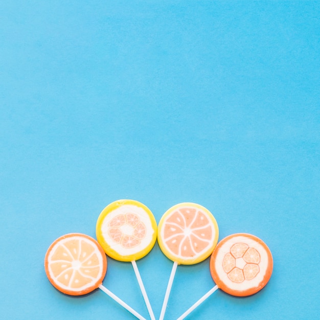 Kolorowe rundy lollipop cukierki rozmieszczone na niebieskim tle