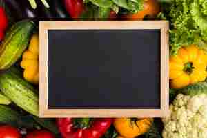 Bezpłatne zdjęcie kolorowe tło z warzywami i tablicą