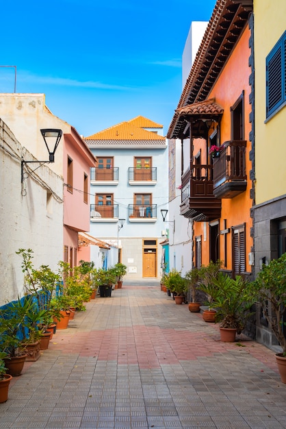 Bezpłatne zdjęcie kolorowi budynki na wąskiej ulicie w hiszpańskim grodzkim punto brava na słonecznym dniu, tenerife, wyspy kanaryjska, hiszpania.