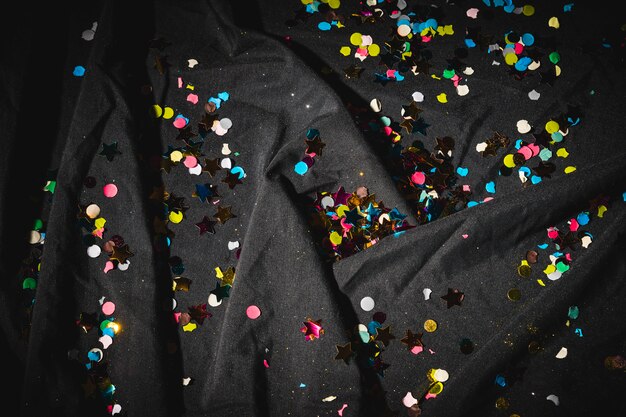 Bezpłatne zdjęcie kolorowi confetti na zmroku zmiętym płótnie