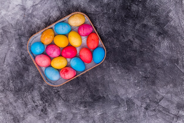 Kolorowi Wielkanocni jajka w pudełku na popielatym stole