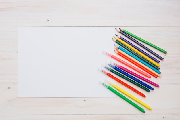 Bezpłatne zdjęcie kolorowy ołówek i flamaster z białym pustym papierem