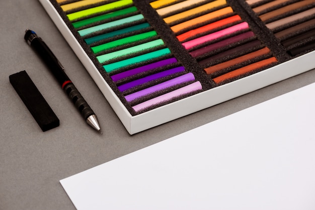 Kolorowy pastel, długopis, papier na szarym stole