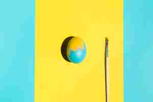 Bezpłatne zdjęcie kolorowy wielkanocny jajko z farby muśnięciem na stole