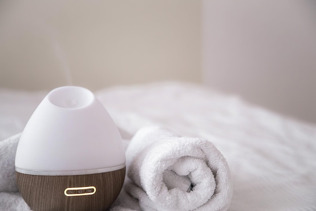Bezpłatne zdjęcie kompozycja spa z dyfuzorem zapachowym i ręcznikiem na rozmytym tle