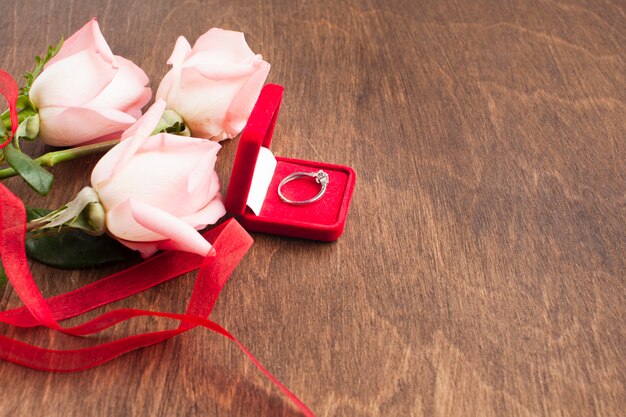 Kompozycja widoku z góry z różami i pierścionkiem zaręczynowym