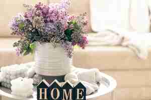 Bezpłatne zdjęcie kompozycja ze świeczkami z kwiatami bzu i dekoracyjnym słowem do domu