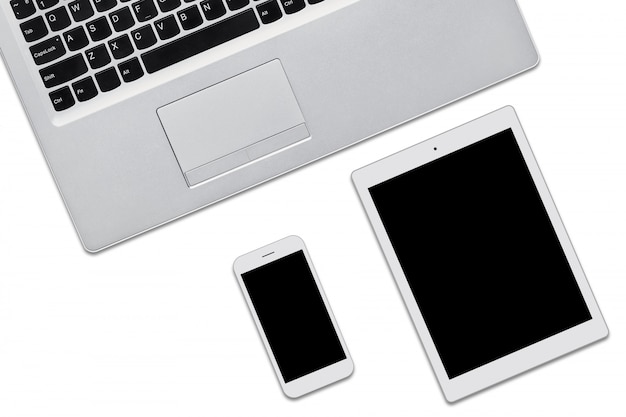 Komputer przenośny, tablet i telefon komórkowy na białym tle z miejsca kopiowania tekstu reklamowego lub promocyjnego. Trzy nowoczesne urządzenia z pustymi ekranami. Widok z góry aktualnych gadżetów.