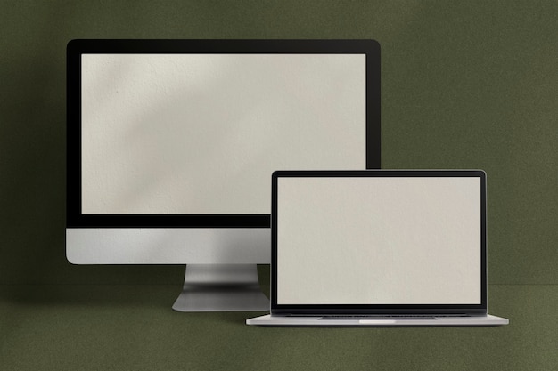 Komputer stacjonarny i laptop z ekranem cyfrowym na zielonym tle