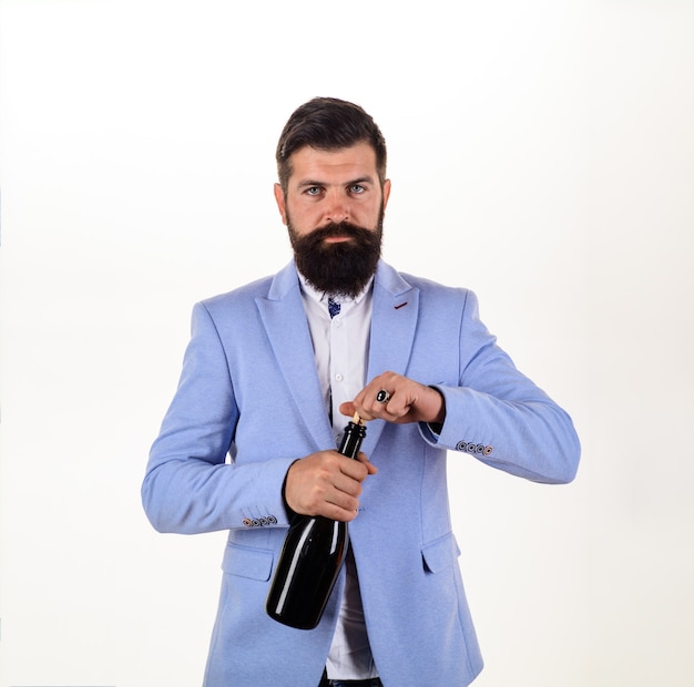Koncepcja alkoholu i wakacji brodaty mężczyzna otwiera sommeliera z butelką wina