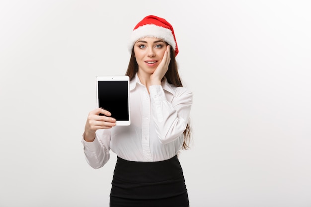 Koncepcja biznesowa - młody biznes kaukaski kobieta w tematyce bożonarodzeniowej przedstawiający cyfrowy tablet z zaskakującym wyrazem twarzy.