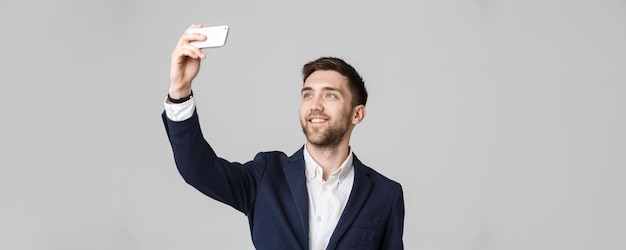 Koncepcja Biznesowa Przystojny Biznesmen robi sobie selfie ze smartfonem Białe Tło