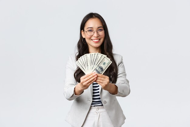 Koncepcja biznesu, finansów i zatrudnienia, przedsiębiorca i pieniądze. Bizneswoman dająca gotówkę, proponująca dobrą pracę ze stabilnymi dużymi dochodami, uśmiechnięta zapraszająca do pracy w swojej firmie