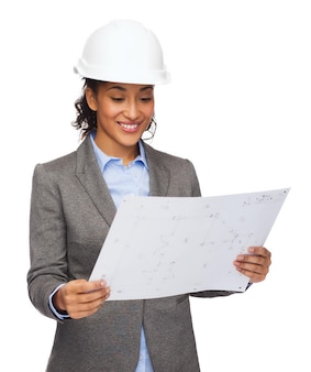 Koncepcja budowy, rozwoju, budowy i architektury - uśmiechnięta bizneswoman w białym kasku patrząca na projekt