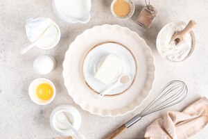 Koncepcja domowego wypieku składniki do robienia ciasta ciasto babeczki jajka mąka masło cynamon mleko cukier na jasnym tle