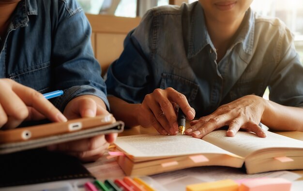 Koncepcja edukacji. Student studiuje i burzy mózgów koncepcji kampusu. Zamknij studentów omawiających ich tematy na książkach lub podręcznikach. Selektywne fokus.