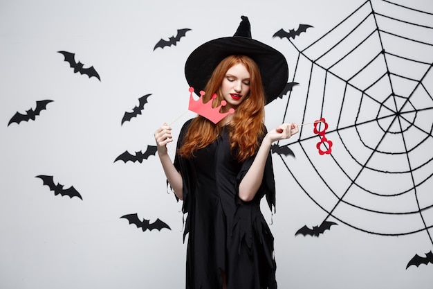 Koncepcja halloween - piękne dziewczyny w czarnych sukniach czarownic posiadających rekwizyty.
