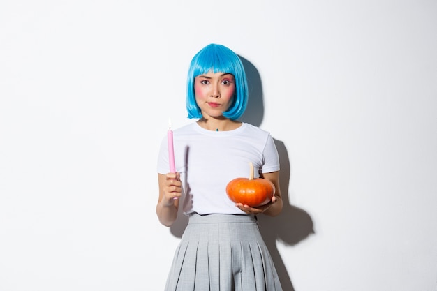 Bezpłatne zdjęcie koncepcja halloween. wizerunek atrakcyjnej sceptycznej azjatyckiej dziewczyny w niebieskiej peruce