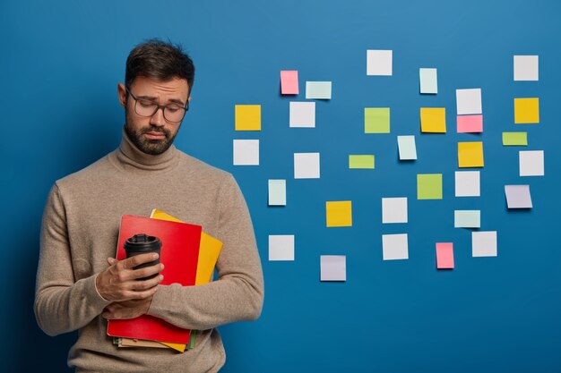 Koncepcja ludzi, edukacji i wiedzy. Smutny niezadowolony mężczyzna z zarostem czuje się zmęczony po wepchnięciu na egzamin