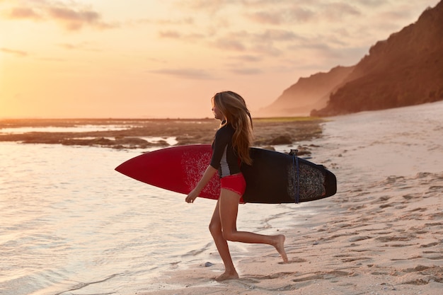 Koncepcja ludzi i podróży. Ujęcie szczupłego surferki o idealnej figurze